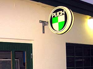 Puch-skylt på kvällen